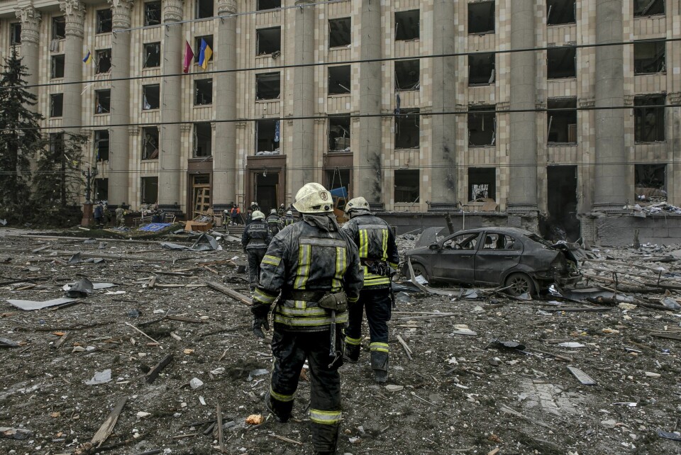 Ukrainsk nødhjelpspersonell utenfor det ødelagte rådhuset i byen Kharkiv. Ukrainsk nødhjelpspersonell utenfor det ødelagte rådhuset i byen Kharkiv.