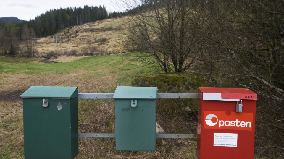 Postkasser i flere farger fotografert på et stativ i Audnedal. Flere ordførere vil beholde dem.