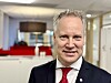Portrett av Arbeiderpartiets kommunalpolitiske talsperson Jon-Ivar Nygård i mørk dress og rødt slips på et kontor.